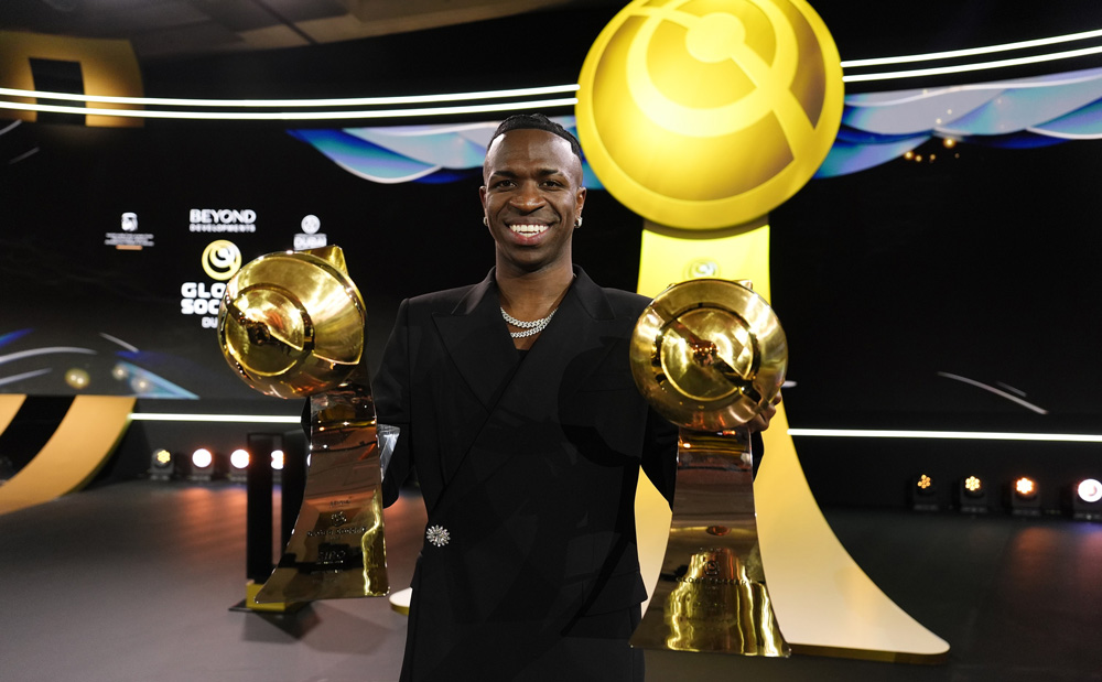 Vinicius-Jr-lifting-his-trophies-after-winning-Best-Men’s-Player-and-Best-Forward-at-the-2024-Beyond-Globe-Soccer-Dubai-Awards